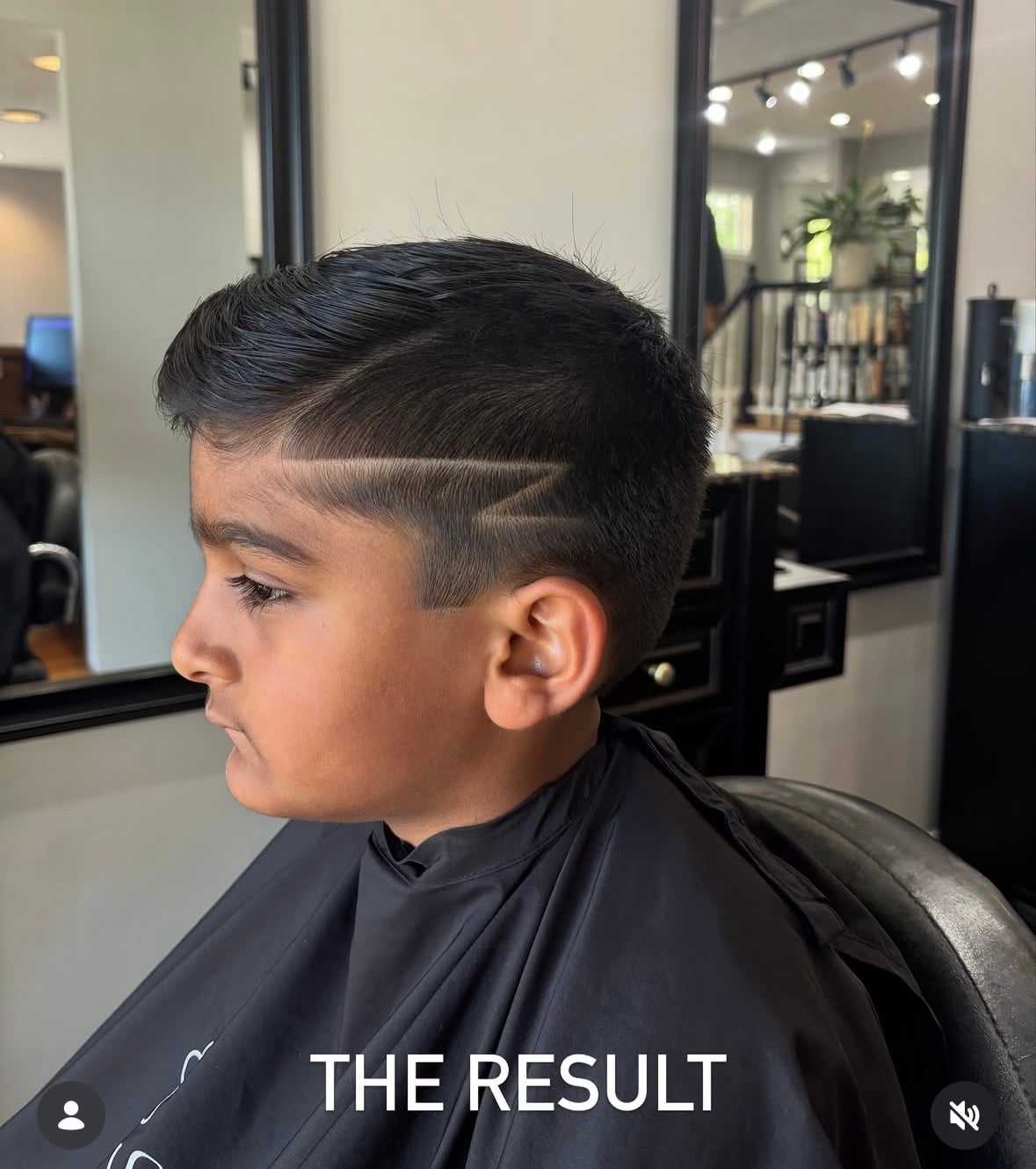 Young boy with a stylish haircut featuring a shaved zigzag design in a salon setting.