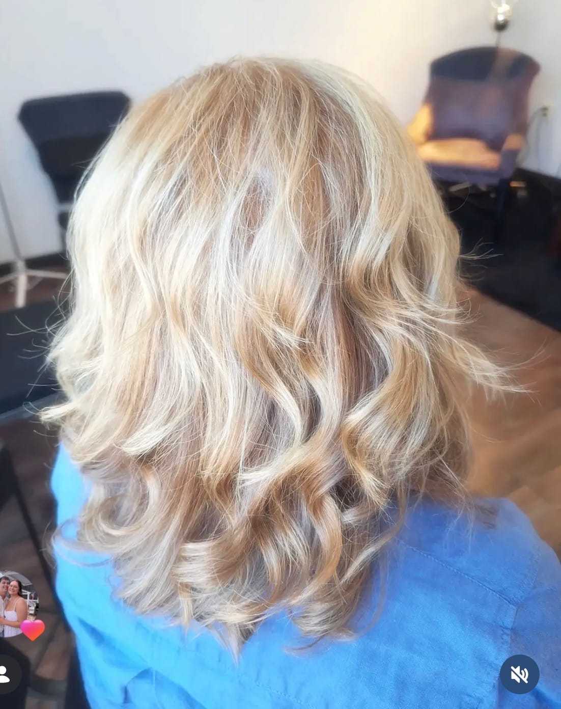 Blonde wavy hair styled for a casual look in a salon setting.