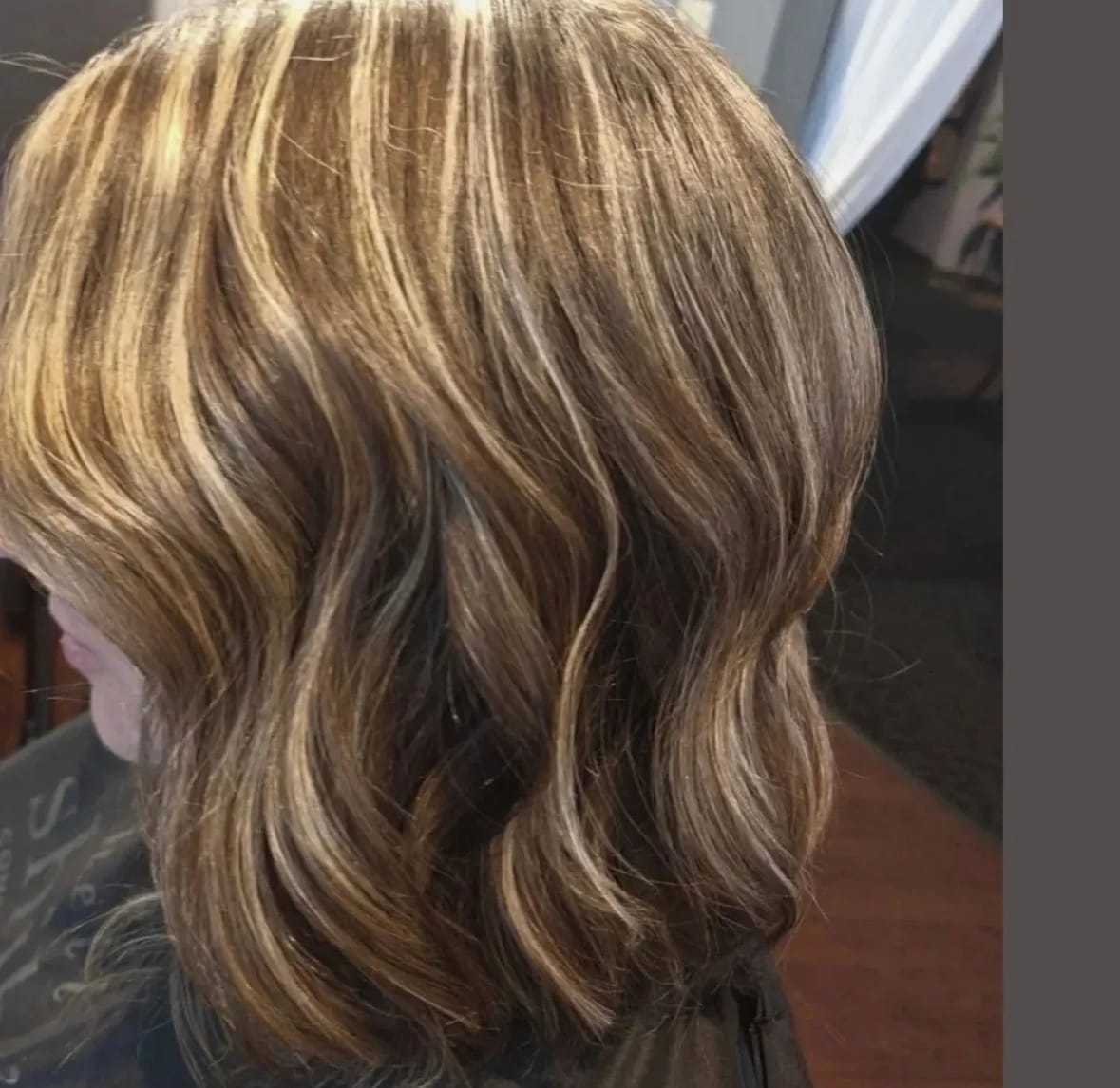 Short wavy blonde hair with highlights, styled in a bob cut.
