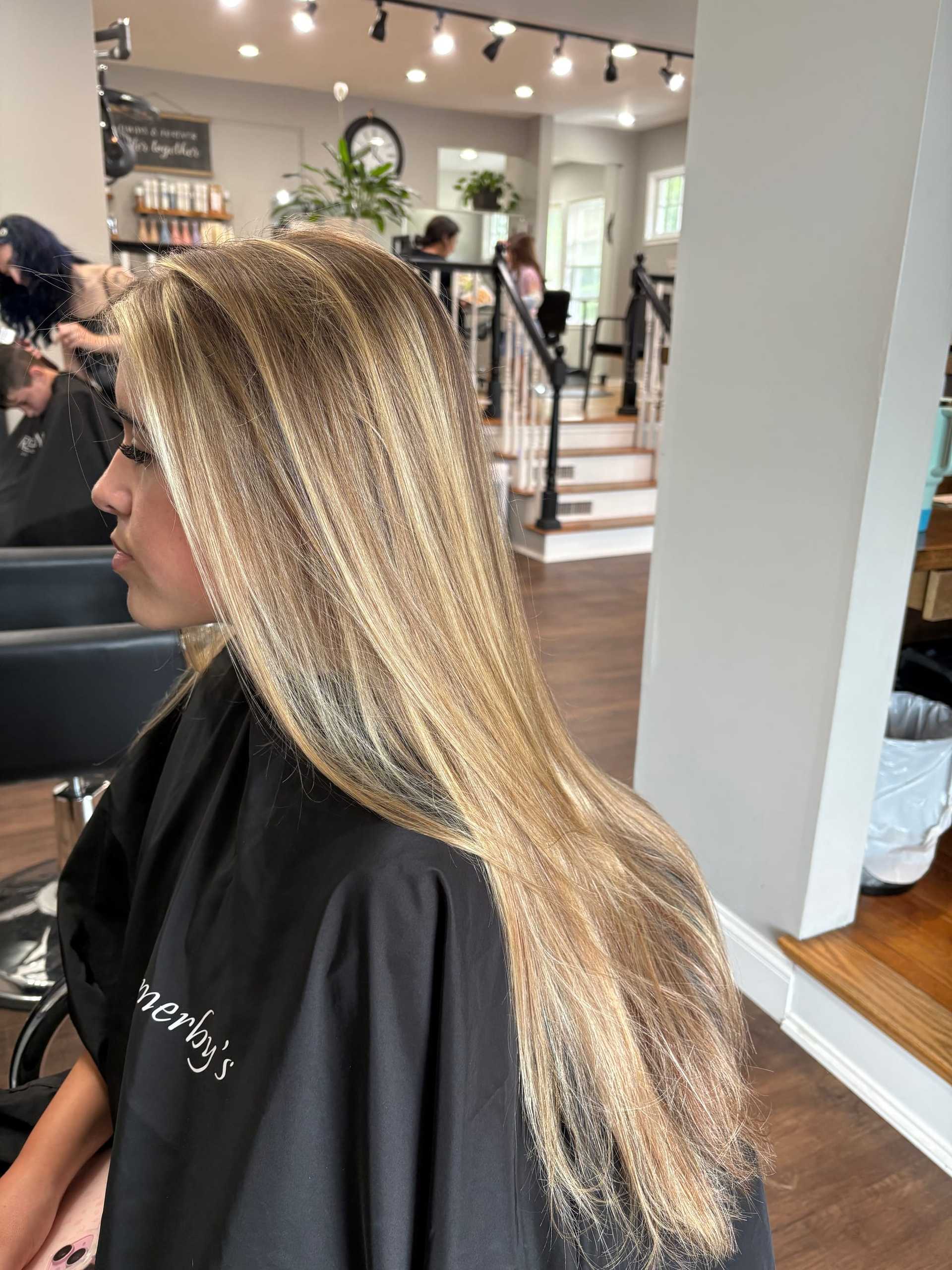 Blonde woman with long hair in a salon, getting a hair treatment.