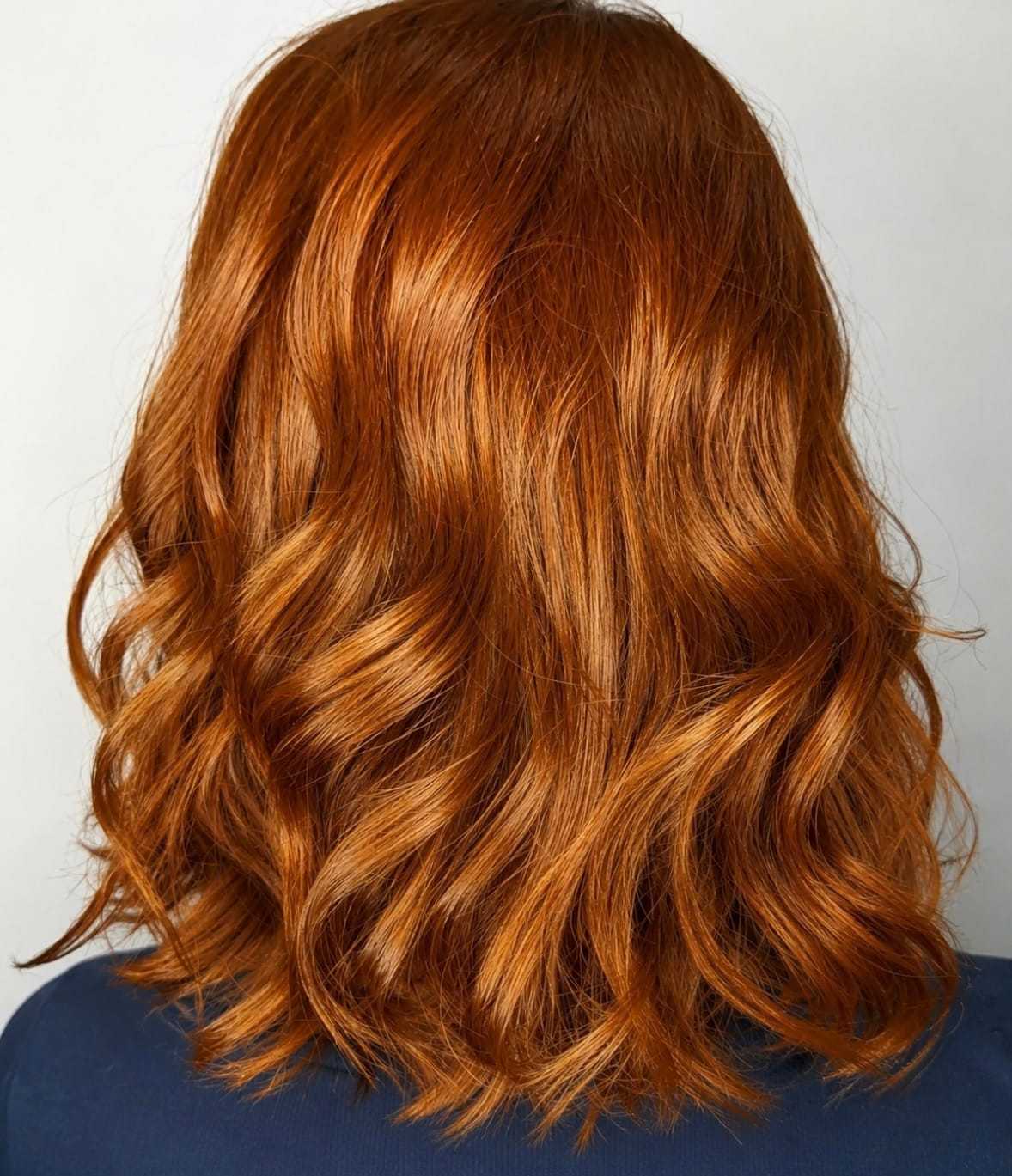 Wavy auburn hair with soft curls against a light background.